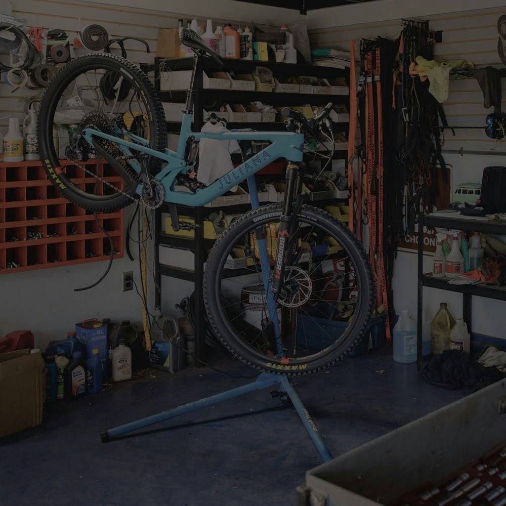 The Juliana Bicycles Joplin full suspension mountain bike mounted to a workstand in a garage