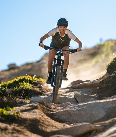 Juliana Bicycles rider Delilah Cupp ridingher Furtado 5 MX full suspension mountain bike down a rocky trail
