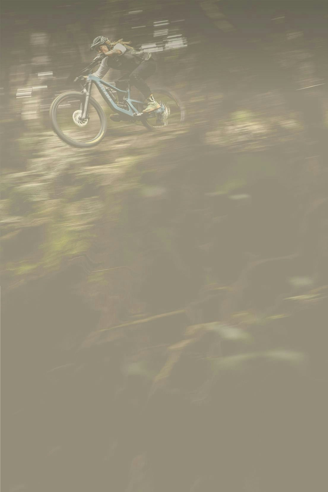 Juliana Athlete Anka Martin riding her Juliana Roubion MX mountain bike in a forested area