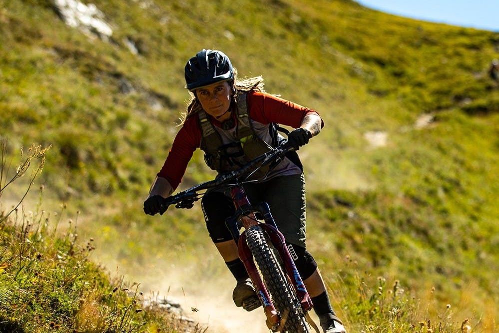Anka Martin riding downhill on a singletrack trail