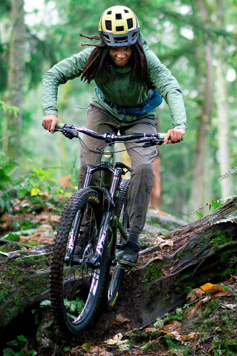 Brooklyn Bell riding her Juliana Mountain Bike off of a log drop