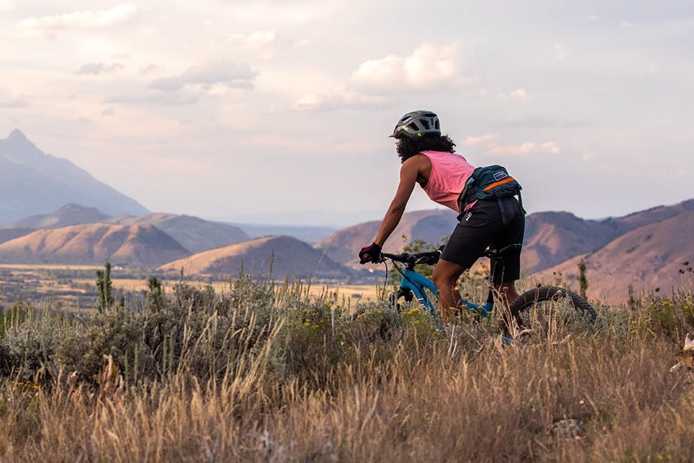 Emilé Newman riding her mountain bike on a singletrack trail 